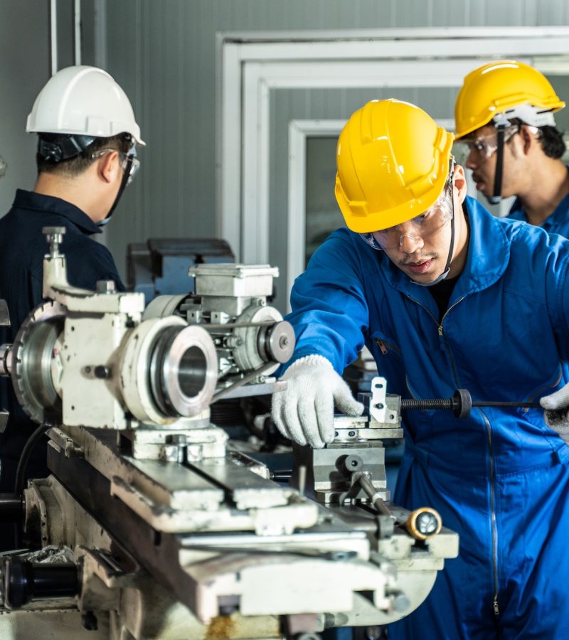 Asian mechanical technicians workers working on operating milling machine for safety precaution.